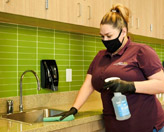 Woman cleaning countertop in office
